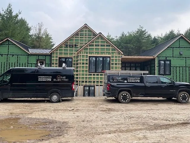 Vine Electric Ltd. van and pickup truck parked at a job site
